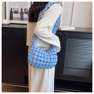 Close-up of a light blue quilted bubble bag with puffy texture and soft fabric detail