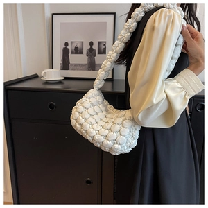 Detailed close-up of white bubble pleated shoulder bag with soft quilted texture