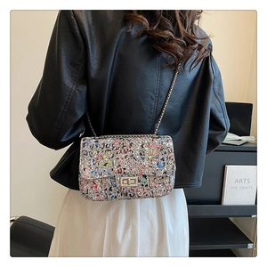 Detail of colorful woven chain bag with silver twist lock on modern background