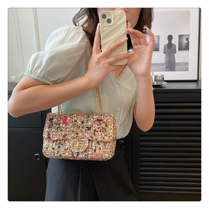 Detail of colorful tweed chain bag with gold rotary clasp and metal strap in mirror selfie