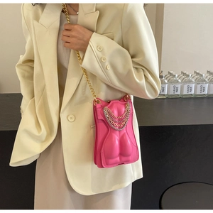 Close-up of a pink female torso shaped crossbody bag with layered metallic chains