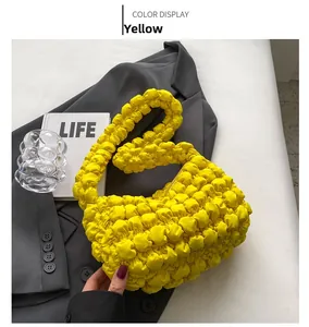 Detailed macro view of yellow bubble texture fabric on a stylish pleated cloud bag