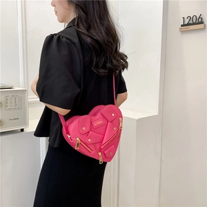 Hot pink heart-shaped crossbody bag featuring motorcycle jacket design with metal zippers
