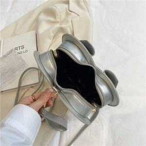 Silver metallic heart-shaped crossbody bag with ear detail and gold hardware zipper