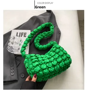 Detail shot of green bubble pleated shoulder bag texture with soft fabric handle