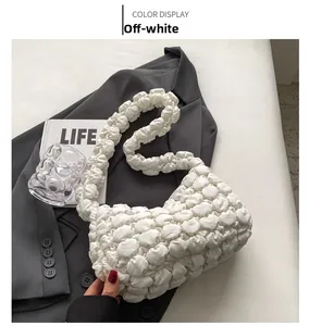Detailed view of the off-white puffy bubble textured shoulder bag on a grey blazer