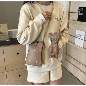 Creative torso-shaped leather crossbody bag featuring layered gold chains and slim strap