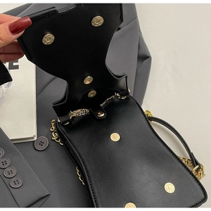 Close-up of black PU leather crossbody bag with dual magnetic buckles and gold chain