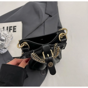 Detail of black leather bag with gold and silver chain and buckle closure hardware