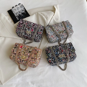 Flat lay of colorful tweed shoulder bags with metal chain straps and square locks