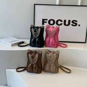 Creative torso-shaped crossbody bags in black, pink, and brown with chain details
