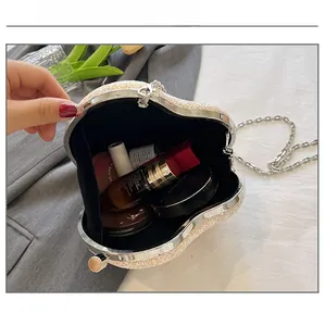 Detail view of the sequined heart evening bag interior with lipstick and makeup essentials
