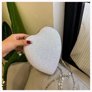 Close-up of heart-shaped glitter clutch with silver chain strap and metallic frame