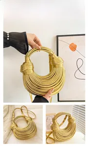 Detail of hand-woven gold knot handbag showing tiered metallic texture and leather shoulder strap