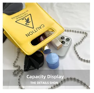 Detail view of yellow crossbody bag interior showing phone and lipstick capacity