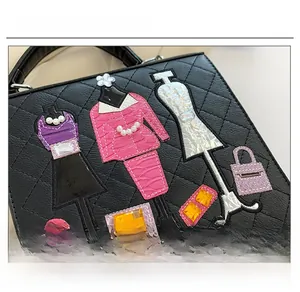 Detail of black quilted leather handbag featuring stylish patchwork embroidery and gemstones