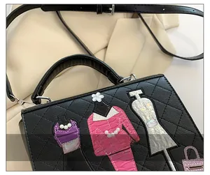 Detail of black quilted handbag featuring fashion model patchwork and white pearl accents