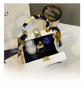 Internal storage view of white box bag with silk scarf handle and golden chain