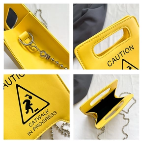 Detail view of yellow caution bag showing silver bead chain and magnetic clasp closure