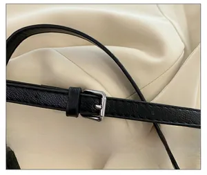 Macro shot of silver square metal buckle and black lychee texture leather strap details
