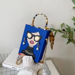 Detail of royal blue box bag with pop art portrait, silk scarf handle and gold chain