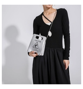 Detail of silver caution mini bag with ball chain strap and metallic finish