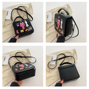 Detail of black quilted leather handbag with colorful fashion embroidery and rhinestones