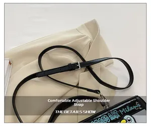 Détail de la bandoulière réglable en cuir avec boucle argentée sur le sac brodé
