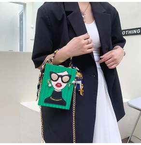 Detail of green rigid box bag featuring cartoon portrait and scarf-wrapped handle