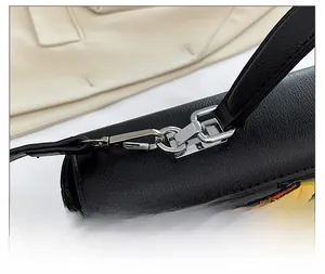 Gros plan sur la boucle en métal argenté d'un sac à bandoulière noir brodé de qualité