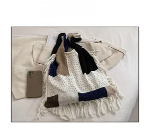 Detail of bohemian knit tote bag showing multi-color patchwork and long tassel fringes