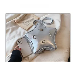 Silver star-shaped crossbody bag with metallic moon ornaments and phone size comparison