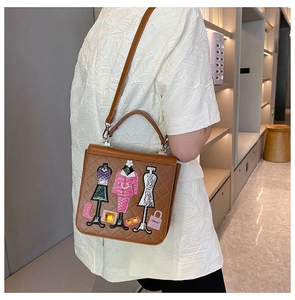 Detail of brown quilted bag with fashion embroidery patches and leather texture