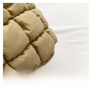 Gros plan sur le tissu matelassé kaki montrant la texture douce du sac nuage