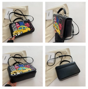 Detail view of retro Baroque handbag with colorful NYC taxi embroidery and black leather finish