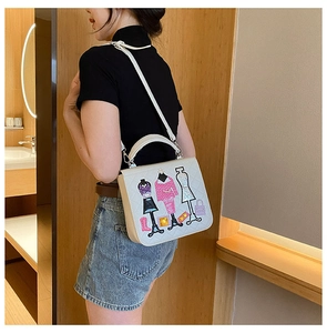 Detail of elegant beige crossbody bag with colorful fashion embroidery and slim strap