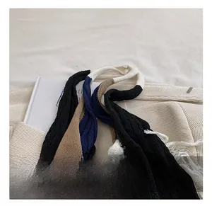 Detailed view of color-block knit tote bag featuring woven handles and long decorative tassels