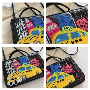 Detail of vintage baroque handbag featuring NYC embroidery, taxi appliques and rhinestones