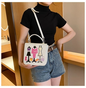 Detail view of a white embroidered crossbody bag with stylish fashion figure patterns