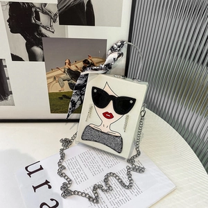 Detail of white box bag with sunglass lady art, silver handle and printed silk scarf