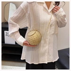 Sparkling gold sphere evening bag with rhinestone detailing worn as a crossbody bag