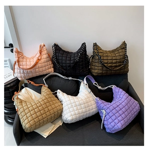Gros plan détaillé de sacs cabas matelassés colorés sur un canapé gris moderne