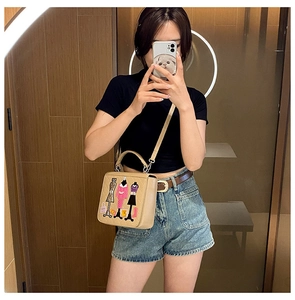Detail of beige square crossbody bag with embroidered mannequin and colorful dress design