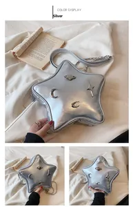 Detail of silver star-shaped crossbody bag with Y2K metallic charms and chain strap
