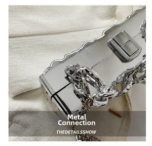 Nahaufnahme der gewellten Acryltasche mit silbernem Metallverschluss und Kettendetails