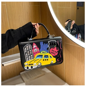 Detail of vintage black box bag with colorful NYC-themed embroidery and silver hardware