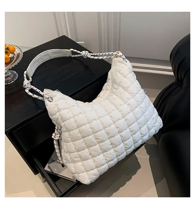 Détail du sac matelassé blanc montrant la texture douce et la bandoulière en corde tressée