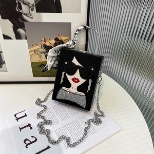Detail view of a black box bag with a fashion illustration and silk scarf handle