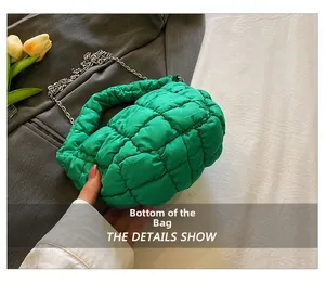 Vista detallada del fondo del bolso acolchado verde esmeralda con costuras cuadradas