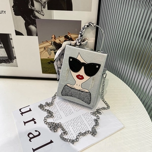 Detail of silver box bag featuring chic sunglasses lady illustration and silk handle